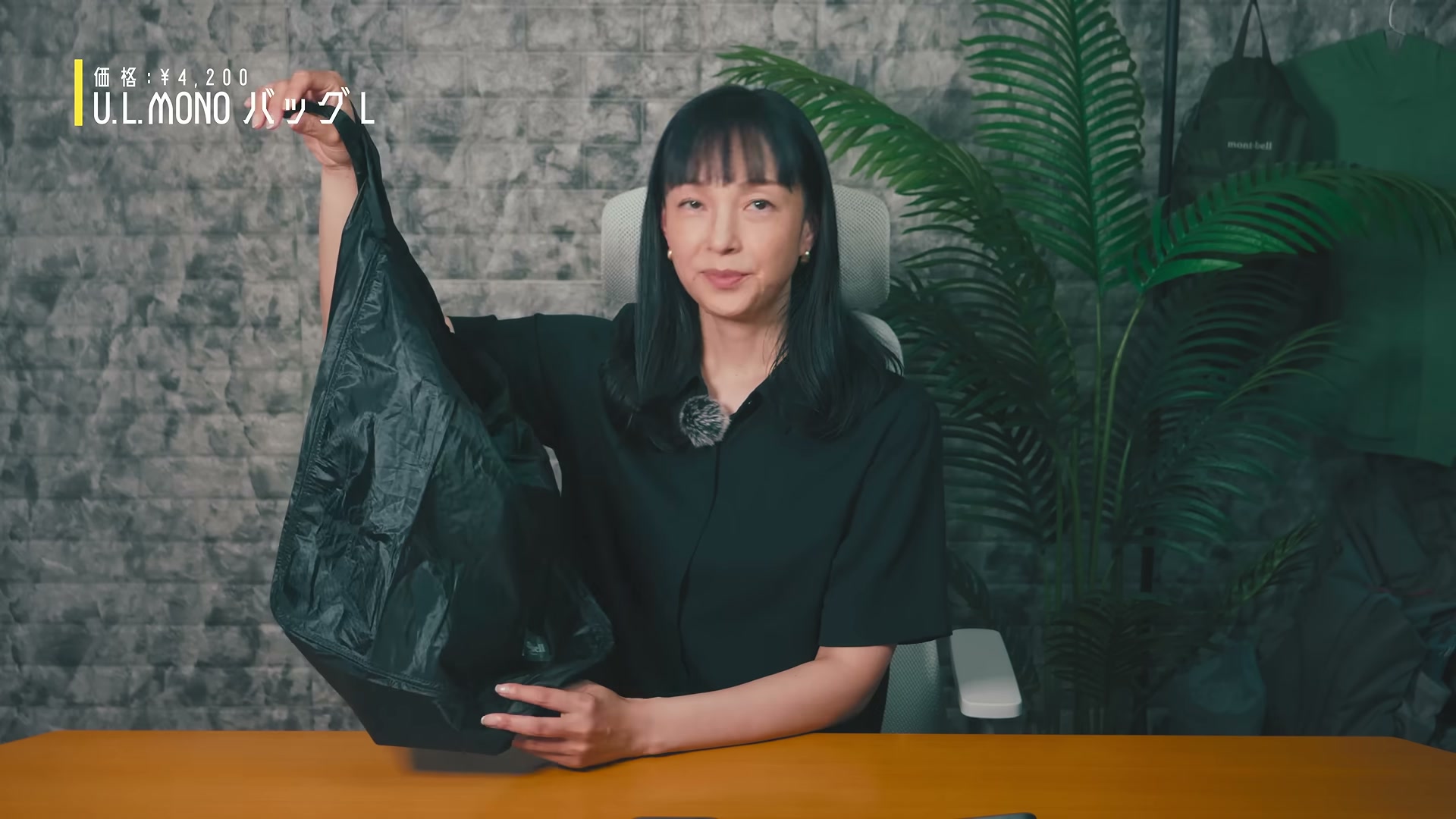 黒いU.L.MONO バッグ Lを手に持って紹介する岩崎良美