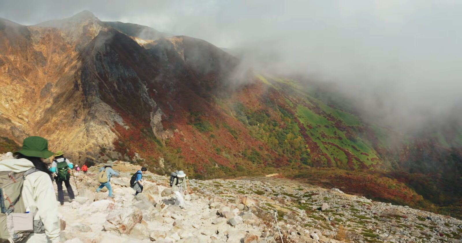 紅葉の那須岳の斜面にガスが流れ込む登山道