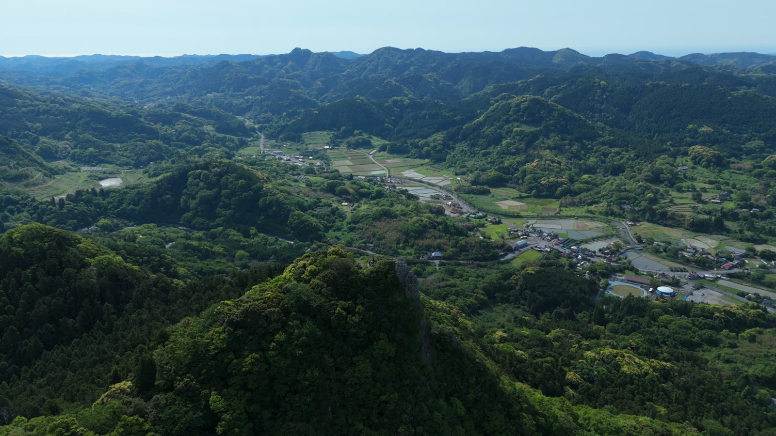 空撮｜岩峰越しに見る谷の集落（伊予ヶ岳）